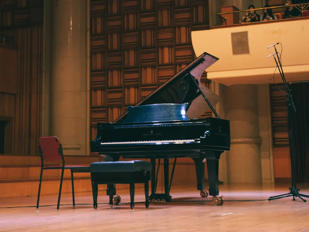 A grand piano on the stage of an empty concert hall before a performance